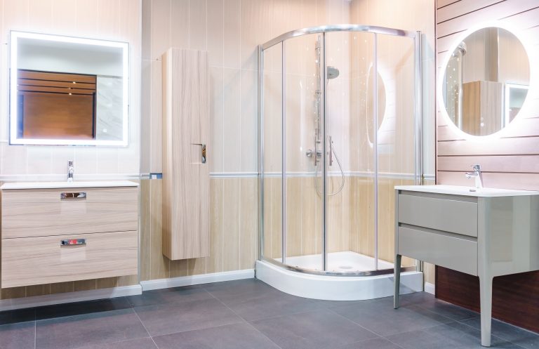Intérieur de salle de bain contemporaine avec des murs blancs, une élégante cabine de douche en verre, des toilettes et un lavabo