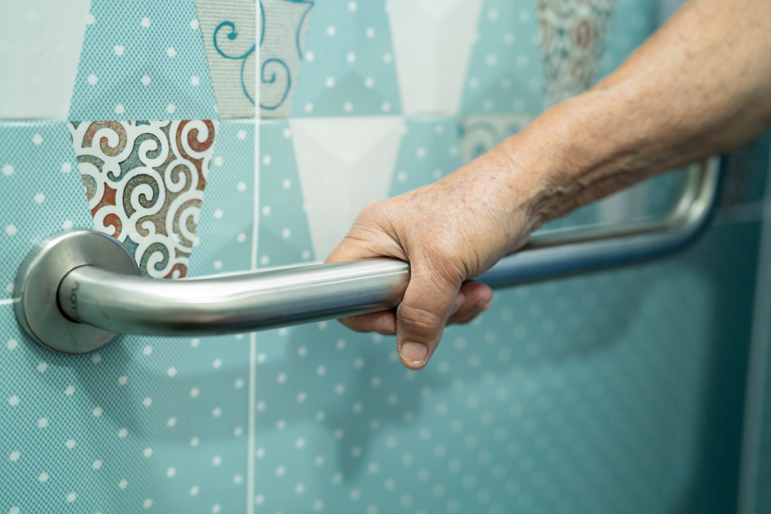 Personne âgée utilisant une poignée de sécurité dans une salle de bain