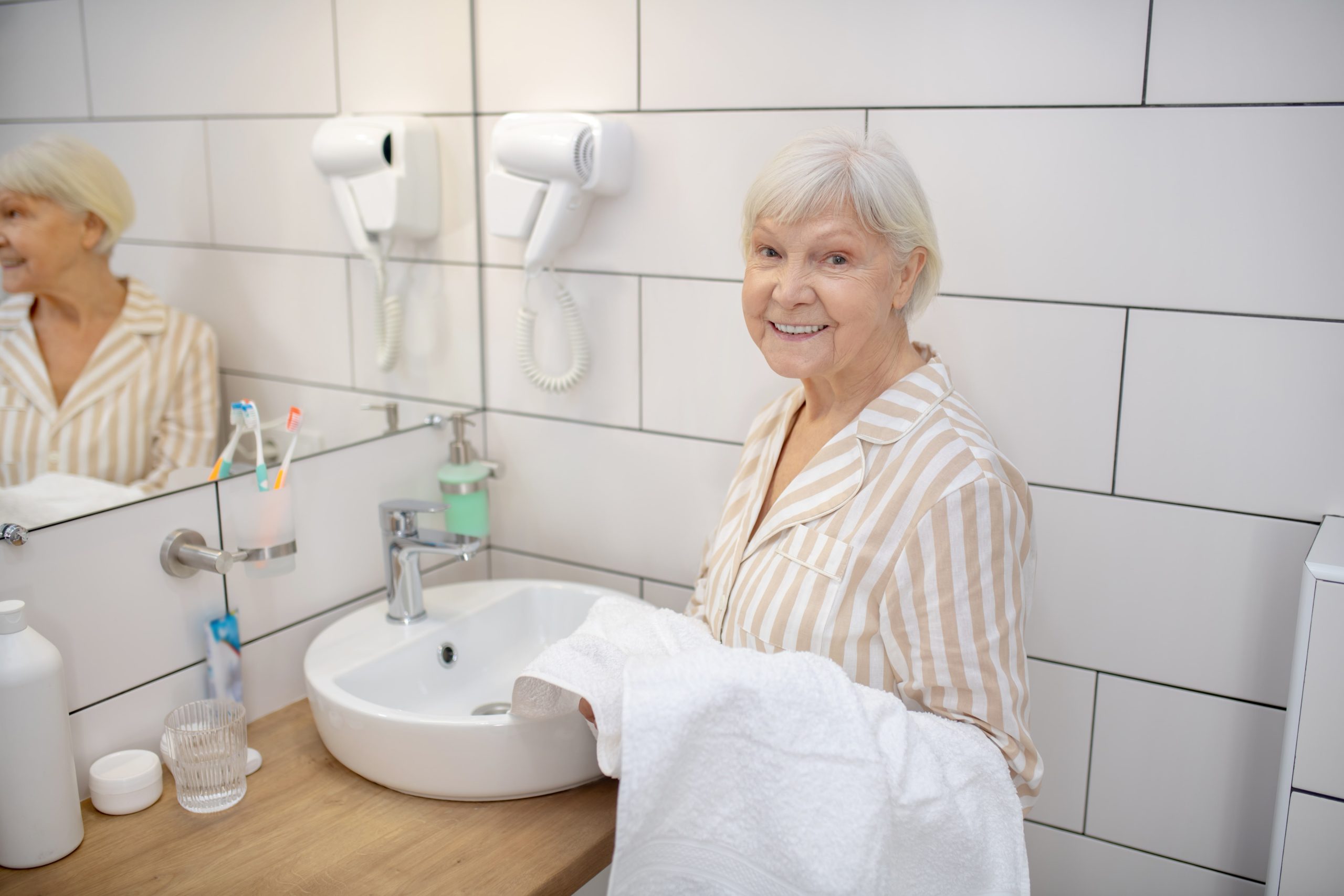 Femme mature aux cheveux gris se détend dans une salle de bain